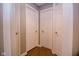Hallway with three white panel doors and laminate flooring at 5964 Laramie Trl, Columbus, IN 47203