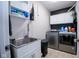 Modern laundry room equipped with a stainless steel sink, washer, dryer, and storage cabinets at 5964 Laramie Trl, Columbus, IN 47203