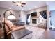 Spacious living room featuring a white brick fireplace, ceiling fan, plush seating and plenty of natural light at 5964 Laramie Trl, Columbus, IN 47203