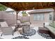 Cozy covered patio with a fire pit, wicker seating, and stylish outdoor rug perfect for outdoor entertaining at 5964 Laramie Trl, Columbus, IN 47203