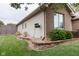Landscaped side yard featuring manicured lawn, shrubs, garden beds, and a fence creating a private outdoor space at 5964 Laramie Trl, Columbus, IN 47203