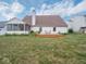 View of the home's backyard with a deck, and a screened-in porch, surrounded by healthy green grass and flower beds at 7119 Topp Creek Ct, Indianapolis, IN 46214
