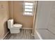 Bathroom featuring toilet, tub, and window at 1011 S Elm St, Muncie, IN 47302