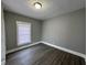 An empty room features wood floors, gray walls, a window, and white trim at 2869 Stuart St, Indianapolis, IN 46218