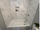 A close-up of a white tiled shower with a shower head and niche at 2869 Stuart St, Indianapolis, IN 46218