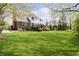 Expansive backyard featuring a large, well-maintained lawn and a charming two-story home with a deck at 13668 Cheswick Blvd, Carmel, IN 46032
