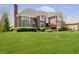 Beautiful brick home with a well-maintained lawn and mature trees at 13668 Cheswick Blvd, Carmel, IN 46032
