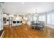 Spacious kitchen and dining area with hardwood floors, white cabinetry, stainless steel appliances, and large windows at 13668 Cheswick Blvd, Carmel, IN 46032