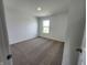 Bright bedroom with neutral carpet, white walls, and a large window, offering a serene and inviting space at 3202 W Longbranch Dr, Monrovia, IN 46157