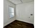 A simple room with white walls and dark wood floors and a single window with blinds at 324 N Tacoma Ave, Indianapolis, IN 46201