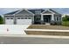 Charming single-story home with gray siding, stone accents, and a three-car garage at 3725 Maple Ridge Trl, Columbus, IN 47201