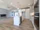 Modern open concept kitchen with an island and gas range flowing into the living room at 3725 Maple Ridge Trl, Columbus, IN 47201