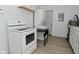 Bright kitchen featuring white appliances, countertops, and cabinets with a laundry area in the background at 3111 Station St, Indianapolis, IN 46218