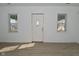 Bright living room with hardwood floors, a modern light fixture, a white front door and natural light from several windows at 3111 Station St, Indianapolis, IN 46218