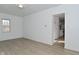 Open living room with hardwood floors, white walls, natural light and a view into the kitchen at 3111 Station St, Indianapolis, IN 46218