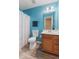 This cheerful bathroom is painted a calming blue and features new vinyl floors, a toilet, and a vanity sink at 3335 Hurst St, Whiteland, IN 46184
