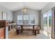 Bright dining area with large windows, a rustic dining table, and a slider to the backyard at 3335 Hurst St, Whiteland, IN 46184