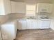 Clean kitchen features white cabinets, laminate countertops, and new floors at 712 Lonsvale Dr, Anderson, IN 46013