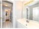 Neutral bathroom with white tile floor, white cabinets and an adjacent room visible through the doorway at 14626 Warner Trl, Westfield, IN 46074