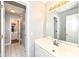 Bright bathroom with large mirror over vanity and open door view to additional sinks and hallway at 14626 Warner Trl, Westfield, IN 46074