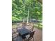 Outdoor deck featuring metal chairs and table with mature trees and view of the green lawn beyond the fence at 14626 Warner Trl, Westfield, IN 46074