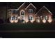 Inviting brick home at night with landscape lighting enhancing its architectural features at 14626 Warner Trl, Westfield, IN 46074