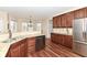 Bright kitchen featuring wood cabinetry, granite countertops, and stainless steel refrigerator at 14626 Warner Trl, Westfield, IN 46074