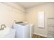 Bright laundry room with white washer and dryer, ample storage, and stainless steel sink at 14626 Warner Trl, Westfield, IN 46074