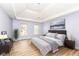 Spacious main bedroom with tray ceiling, chandelier, wood floors, and bright windows at 14626 Warner Trl, Westfield, IN 46074
