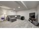 The finished basement provides a comfortable spot to relax with a gray sectional and television at 1487 Brook Mill Ct, Carmel, IN 46032