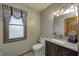 Cozy bathroom with modern vanity, decorative mirror, and window with stylish valance at 1487 Brook Mill Ct, Carmel, IN 46032