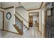 Entryway with wood trim staircase, luxury vinyl plank flooring, and a view of the dining room at 1487 Brook Mill Ct, Carmel, IN 46032