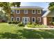 Charming brick two-story home with a well-manicured front yard and inviting curb appeal, with flowers and bushes at 1487 Brook Mill Ct, Carmel, IN 46032