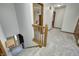 Bright hallway with carpeted stairs, wood railing, and views into other rooms at 1487 Brook Mill Ct, Carmel, IN 46032