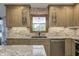 Close up of a kitchen featuring stone backsplash, custom cabinets, and granite countertops at 1487 Brook Mill Ct, Carmel, IN 46032