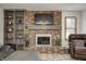 Living room with a cozy brick fireplace, built-in shelving, and comfortable seating at 1487 Brook Mill Ct, Carmel, IN 46032
