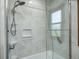 Bathroom shower with a showerhead, built-in shelving, and glass door at 1487 Brook Mill Ct, Carmel, IN 46032