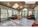 Bright sunroom features wood-paneled ceiling, skylights, and multiple windows offering natural light, with comfortable seating at 1487 Brook Mill Ct, Carmel, IN 46032
