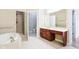 Bright bathroom featuring a soaking tub, walk-in shower, and dual vanity sinks at 350 N Meridian St # 901, Indianapolis, IN 46204
