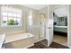 Bathroom with bathtub, shower, and view of a treetop at 11419 Romeo Pl, Fishers, IN 46040