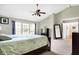 Primary bedroom with high ceilings, large bed, and ensuite bathroom access at 11419 Romeo Pl, Fishers, IN 46040