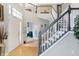 Two-story entryway with hardwood floors, and a dramatic staircase at 11419 Romeo Pl, Fishers, IN 46040