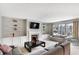 Living room with a fireplace, built-in shelving, and large windows at 11419 Romeo Pl, Fishers, IN 46040