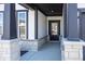 Front entrance with stonework, dark-stained columns, and a black door at 18862 Shefler Blvd, Noblesville, IN 46062