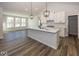 Modern kitchen with white cabinets, a large island, and stainless steel appliances at 18862 Shefler Blvd, Noblesville, IN 46062