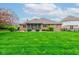 Beautifully landscaped backyard showcasing the brick house and the screened-in porch at 691 Walnut Woods Dr, Greenwood, IN 46142