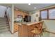 Basement bar area with wooden cabinets, bar stools, and staircase at 691 Walnut Woods Dr, Greenwood, IN 46142