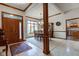 Open-concept dining area with a wooden dining table, large window, and access to the front door and kitchen at 691 Walnut Woods Dr, Greenwood, IN 46142