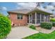 Brick home exterior showing the screened porch, patio, and manicured landscaping at 691 Walnut Woods Dr, Greenwood, IN 46142