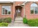 Close-up of front door with glass detailing, surrounded by brick, stone walkway, and trimmed landscaping at 691 Walnut Woods Dr, Greenwood, IN 46142